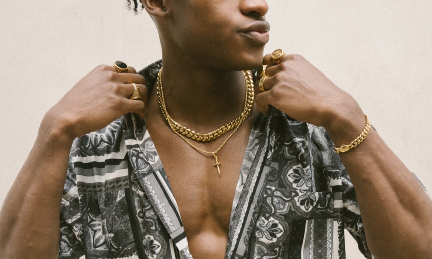 Man in an open collar cuban shirt styling a gold cuban link chain